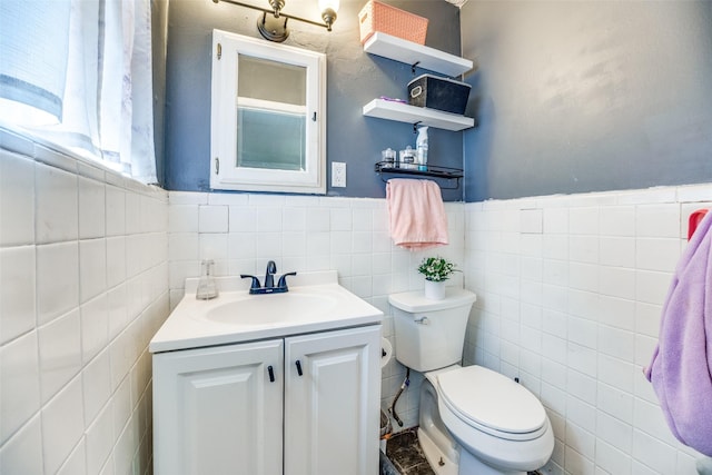 bathroom featuring vanity, tile walls, and toilet