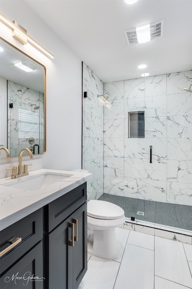 bathroom featuring toilet, vanity, visible vents, marble finish floor, and a marble finish shower