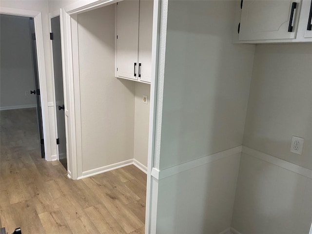 washroom with baseboards and light wood finished floors