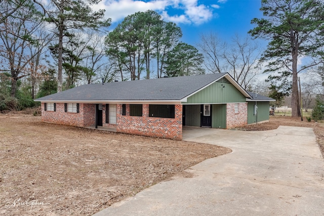 ranch-style house featuring an attached carport, concrete driveway, and brick siding