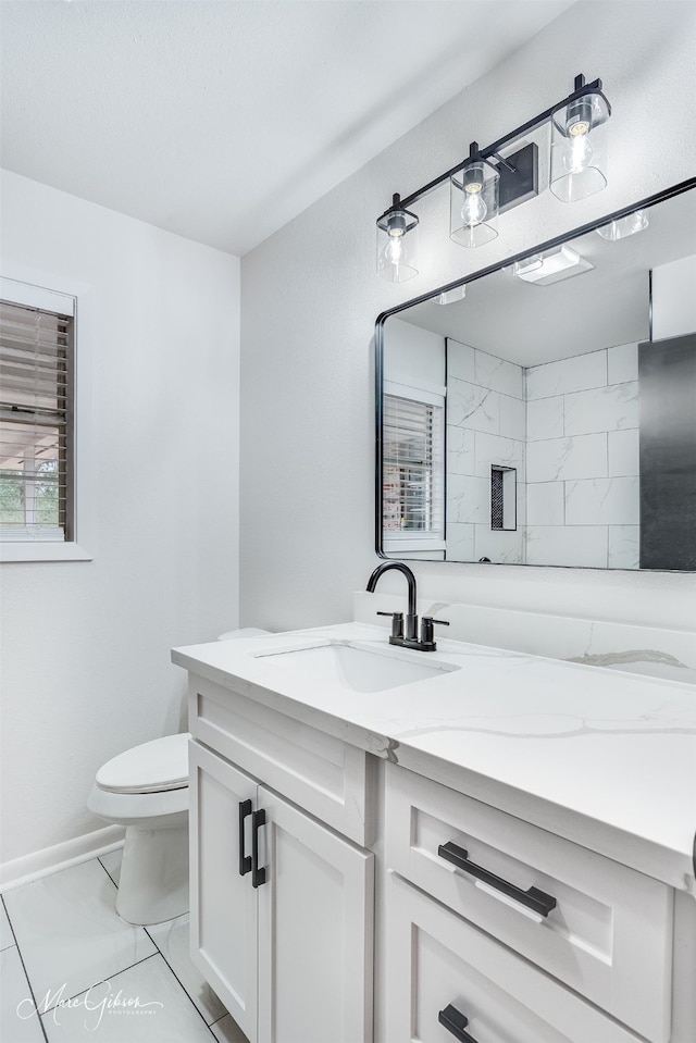 bathroom with marble finish floor, baseboards, vanity, and toilet