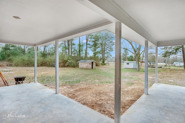 view of patio featuring a storage shed and an outbuilding