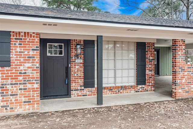 view of exterior entry featuring covered porch