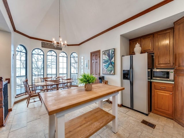 kitchen featuring appliances with stainless steel finishes, butcher block countertops, a chandelier, hanging light fixtures, and crown molding