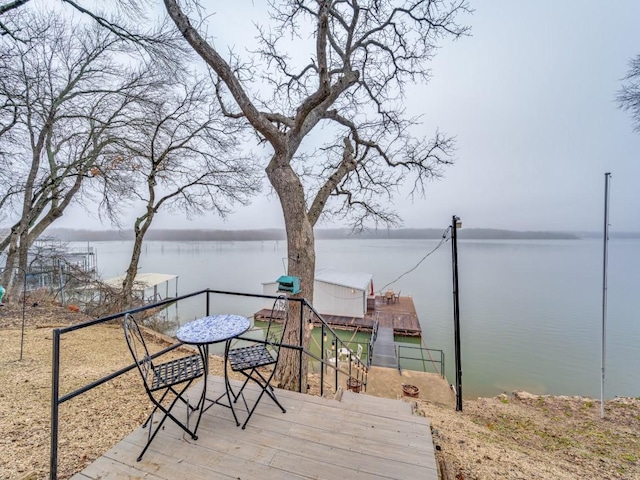 wooden deck with a water view and a dock