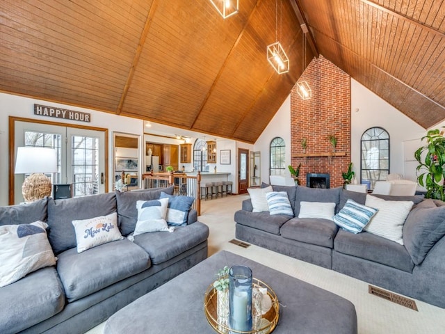 living room with wood ceiling, a fireplace, carpet flooring, and high vaulted ceiling