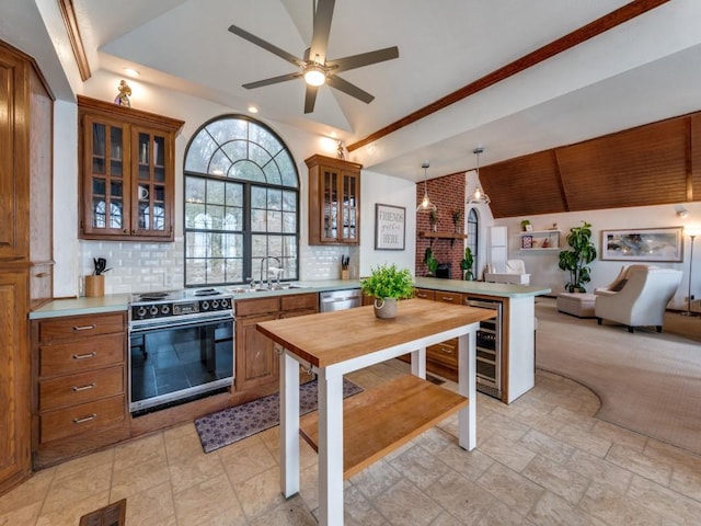 kitchen featuring vaulted ceiling, decorative light fixtures, sink, stainless steel dishwasher, and electric range