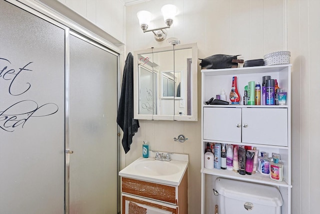 bathroom with toilet, vanity, and an enclosed shower