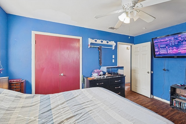 bedroom with dark wood-type flooring, ceiling fan, and a closet