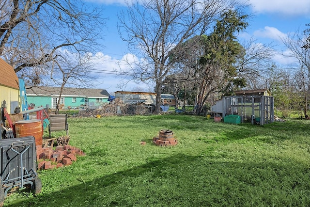 view of yard featuring a fire pit and an outdoor structure