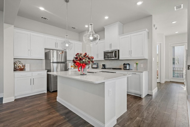 kitchen featuring dark hardwood / wood-style floors, an island with sink, white cabinets, hanging light fixtures, and stainless steel appliances