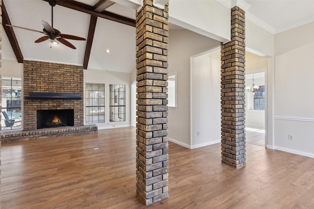 unfurnished living room featuring a healthy amount of sunlight, hardwood / wood-style flooring, ceiling fan, and decorative columns