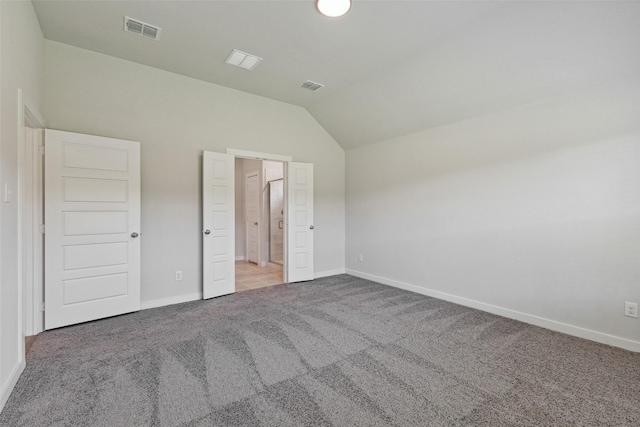 unfurnished bedroom with light carpet and lofted ceiling