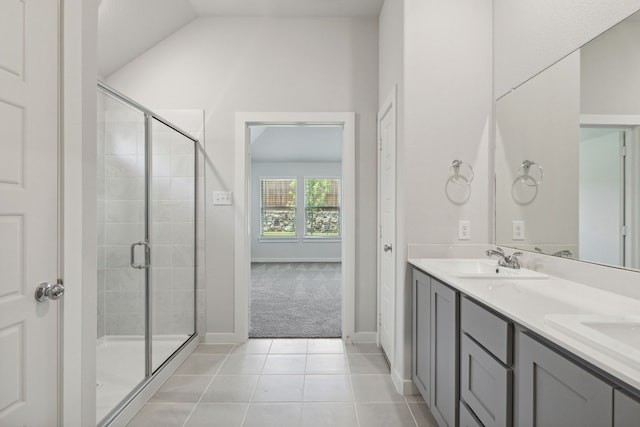 bathroom featuring vanity, a shower with door, vaulted ceiling, and tile patterned floors