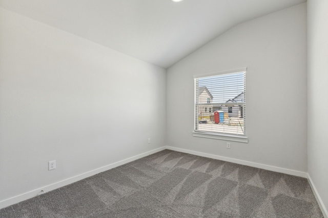 unfurnished room featuring lofted ceiling and carpet floors