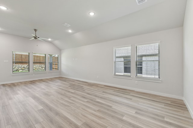 spare room with ceiling fan, vaulted ceiling, and light wood-type flooring