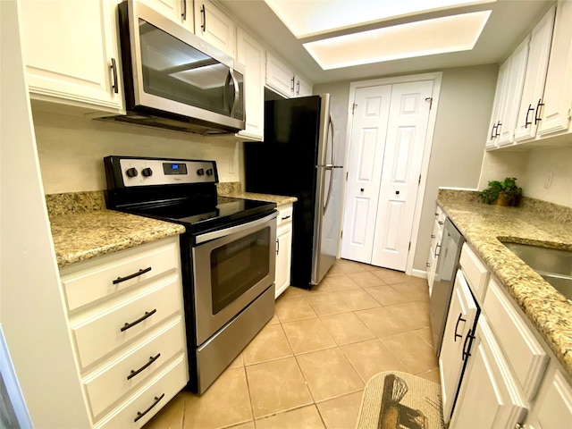 kitchen featuring light stone countertops, white cabinetry, and appliances with stainless steel finishes