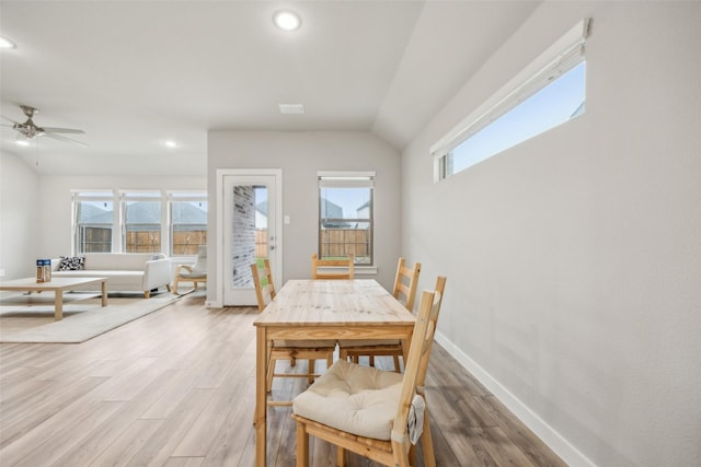 dining room with hardwood / wood-style flooring, ceiling fan, and lofted ceiling