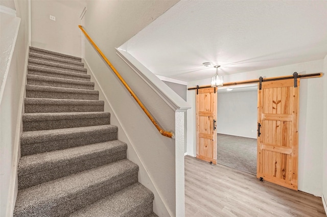 stairs featuring wood-type flooring and a barn door