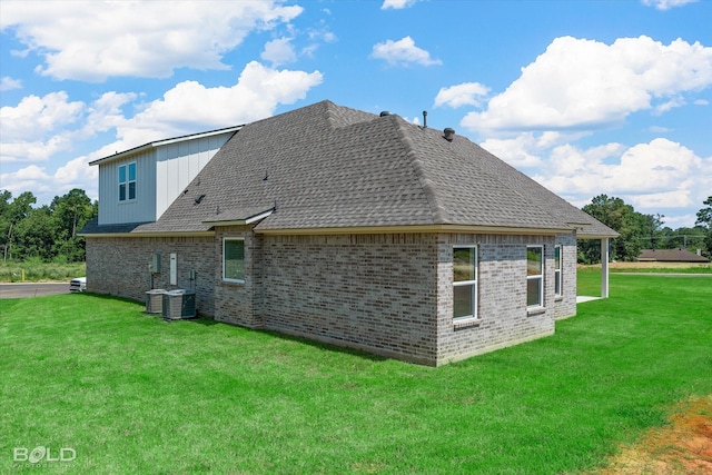 view of side of home featuring central air condition unit and a lawn