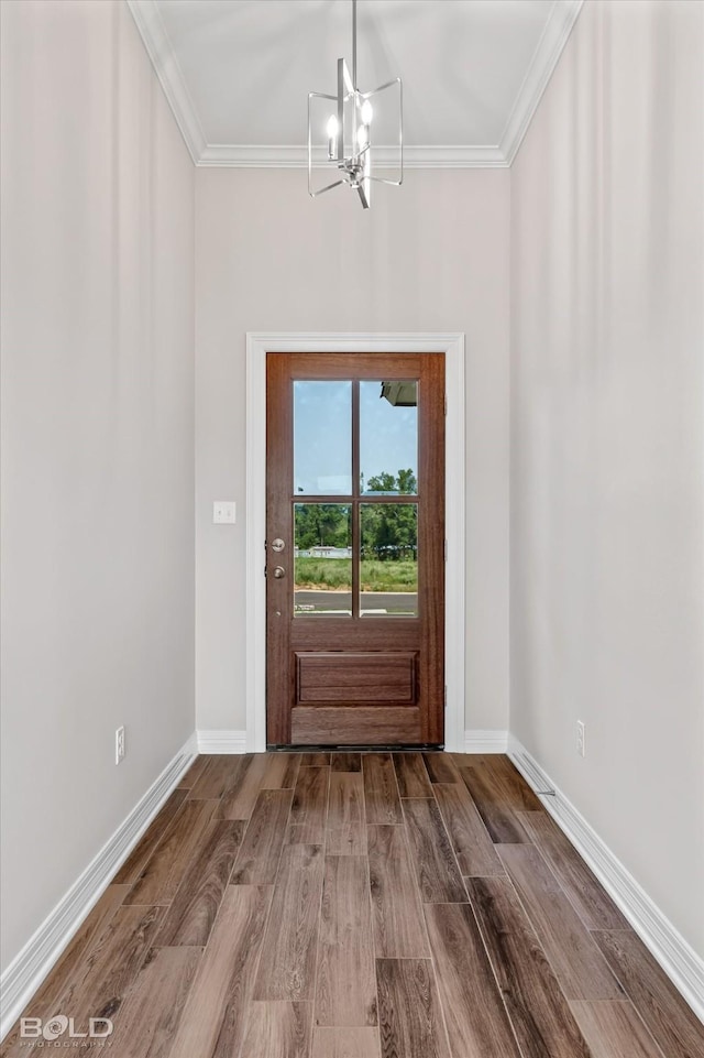 doorway featuring hardwood / wood-style flooring, ornamental molding, and a notable chandelier