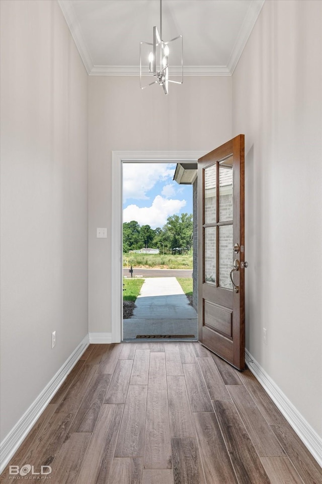 doorway featuring hardwood / wood-style flooring, crown molding, and an inviting chandelier