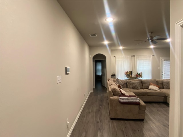 living room featuring ceiling fan and dark hardwood / wood-style floors