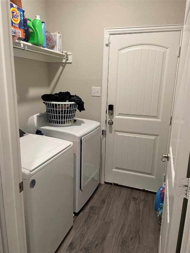 laundry area with dark hardwood / wood-style floors and washing machine and clothes dryer