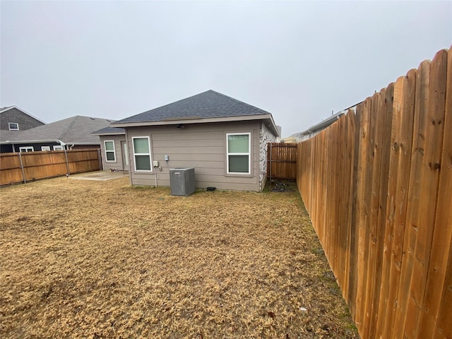 rear view of house featuring central AC