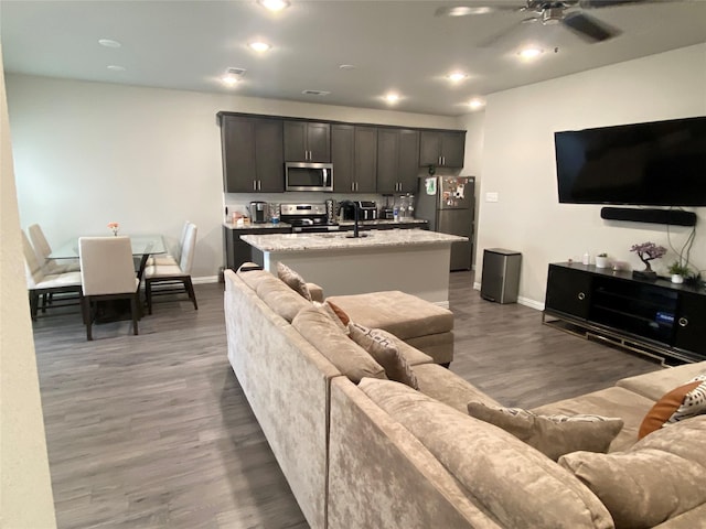 living room with ceiling fan and dark hardwood / wood-style floors