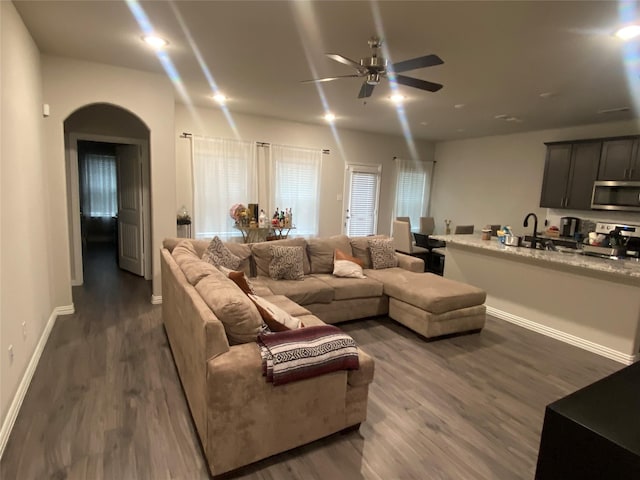 living room with ceiling fan, dark hardwood / wood-style floors, and sink