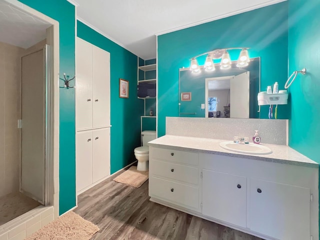 bathroom with a shower, hardwood / wood-style floors, vanity, and toilet