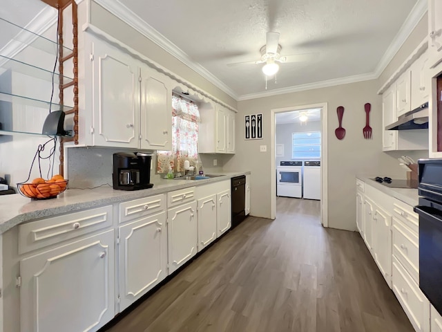 kitchen featuring white cabinetry, ornamental molding, washer and clothes dryer, and black appliances