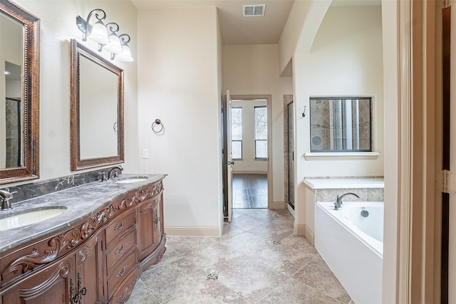 bathroom featuring independent shower and bath, vanity, and tile patterned floors