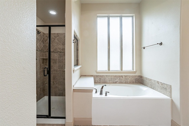 bathroom featuring shower with separate bathtub