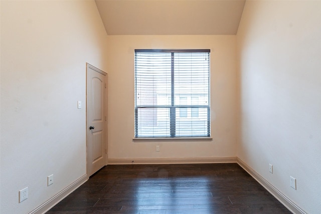 empty room with dark wood-type flooring and vaulted ceiling