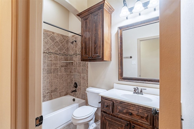 full bathroom featuring tiled shower / bath, vanity, and toilet