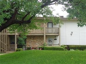 back of property featuring a lawn and a balcony