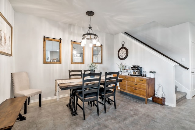 tiled dining room featuring a notable chandelier