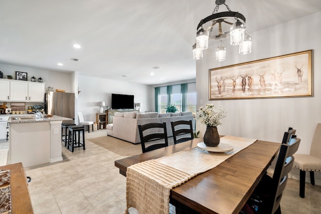 dining area featuring sink and a notable chandelier