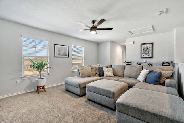 living room with ceiling fan, carpet floors, and a textured ceiling