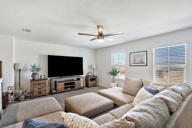 carpeted living room featuring a textured ceiling and ceiling fan