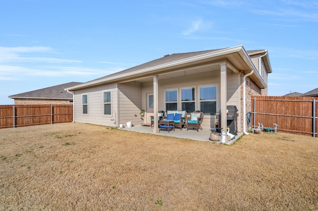 rear view of house featuring a yard and a patio