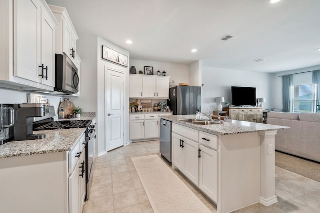 kitchen featuring an island with sink, appliances with stainless steel finishes, sink, and white cabinets