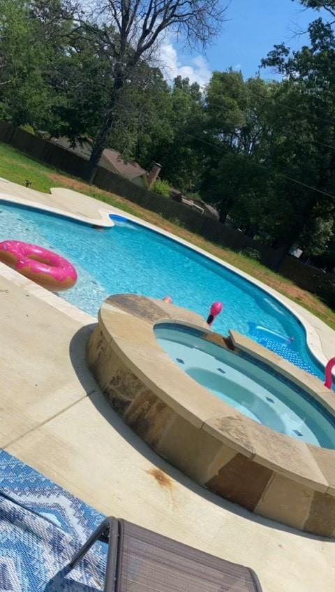 view of swimming pool featuring an in ground hot tub