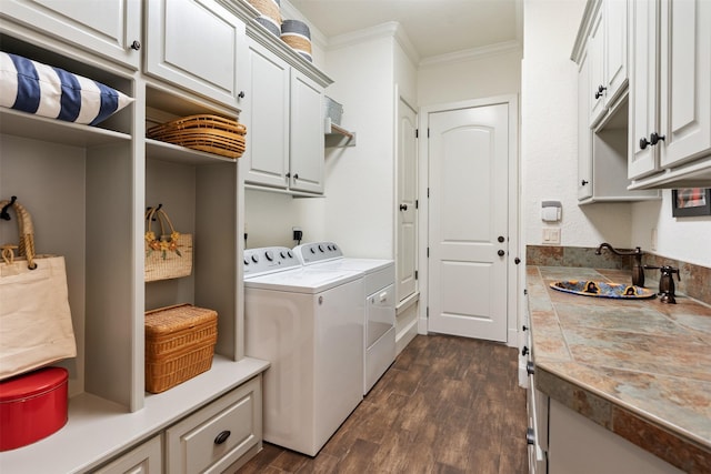 laundry area featuring cabinets, crown molding, washer and dryer, and dark wood-type flooring