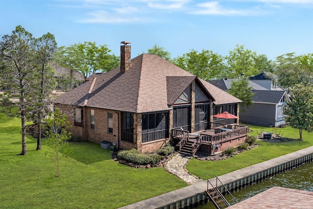 back of house featuring a deck with water view and a lawn