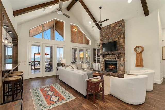 living room featuring french doors, a stone fireplace, high vaulted ceiling, dark hardwood / wood-style flooring, and beamed ceiling