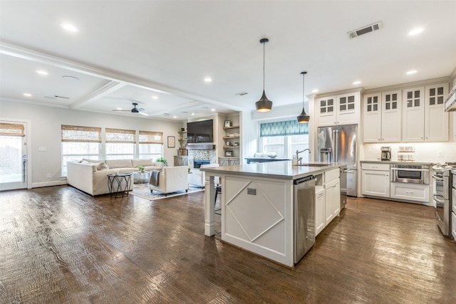 kitchen with a wealth of natural light, an island with sink, white cabinetry, sink, and stainless steel appliances