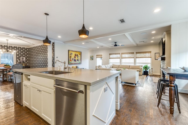 kitchen with sink, hanging light fixtures, dark hardwood / wood-style floors, white cabinets, and a center island with sink